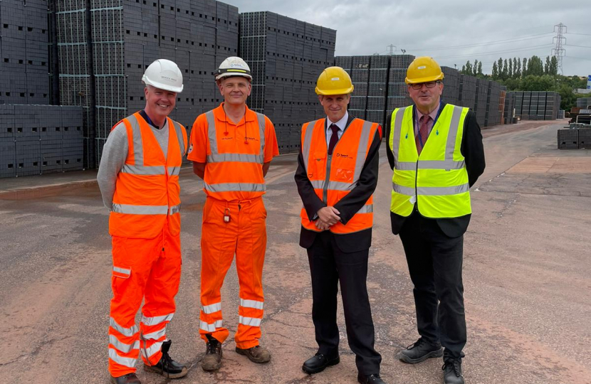 Sir Gavin Williamson at the Ibstock Brick site in front of a pallet of Staffordshire Blue Bricks 