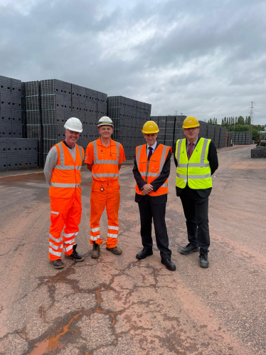 Sir Gavin Williamson at the Ibstock Brick site in front of a pallet of Staffordshire Blue Bricks 